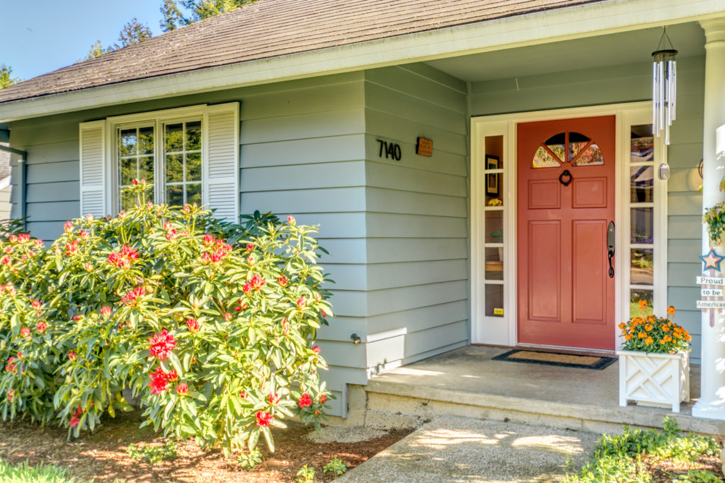 A vivid front door color against a more serene house color underscores the importance of curb appeal.